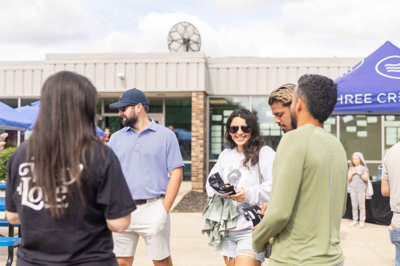 People standing around talking outside the building after a Sunday service.