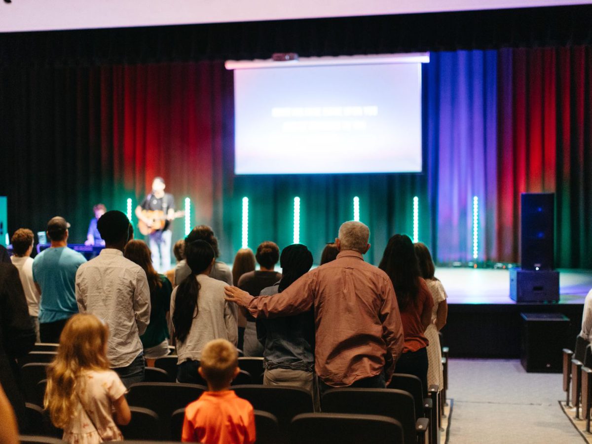 People arriving and finding seats before a Sunday service.