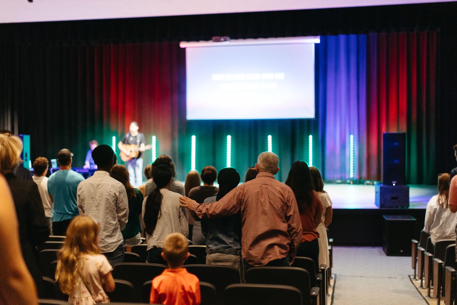 People arriving and finding seats before a Sunday service.