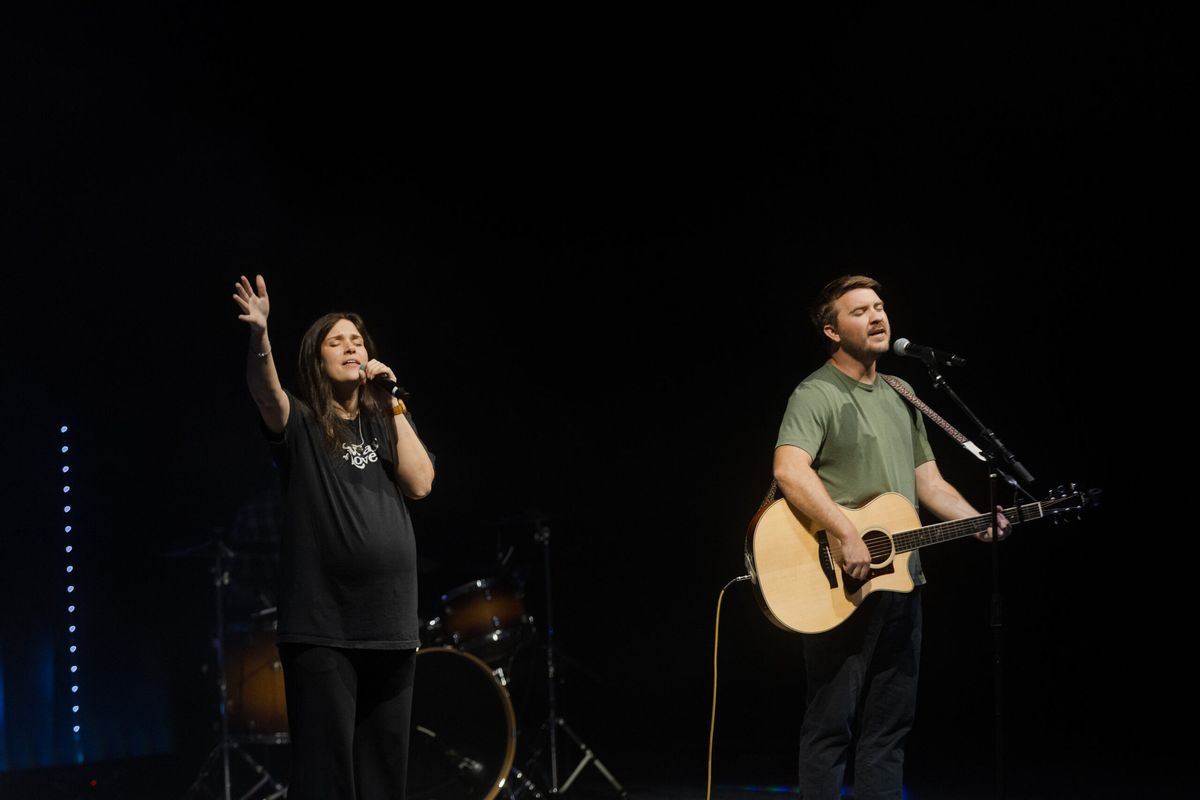 Two worship leaders singing on stage during a Sunday service.